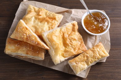 Photo of Delicious puff pastry served on wooden table, top view