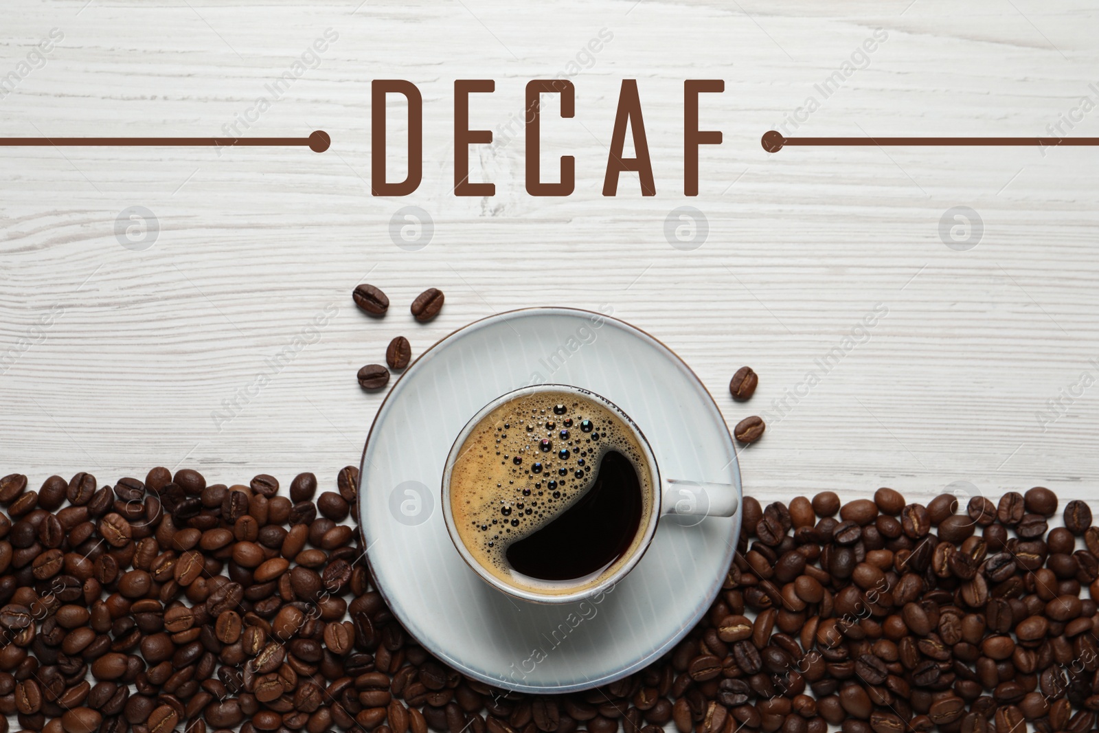 Image of Cup of aromatic decaf coffee and beans on white wooden table, flat lay
