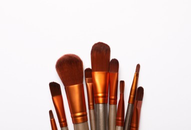 Photo of Set of makeup brushes on white background, flat lay. Space for text