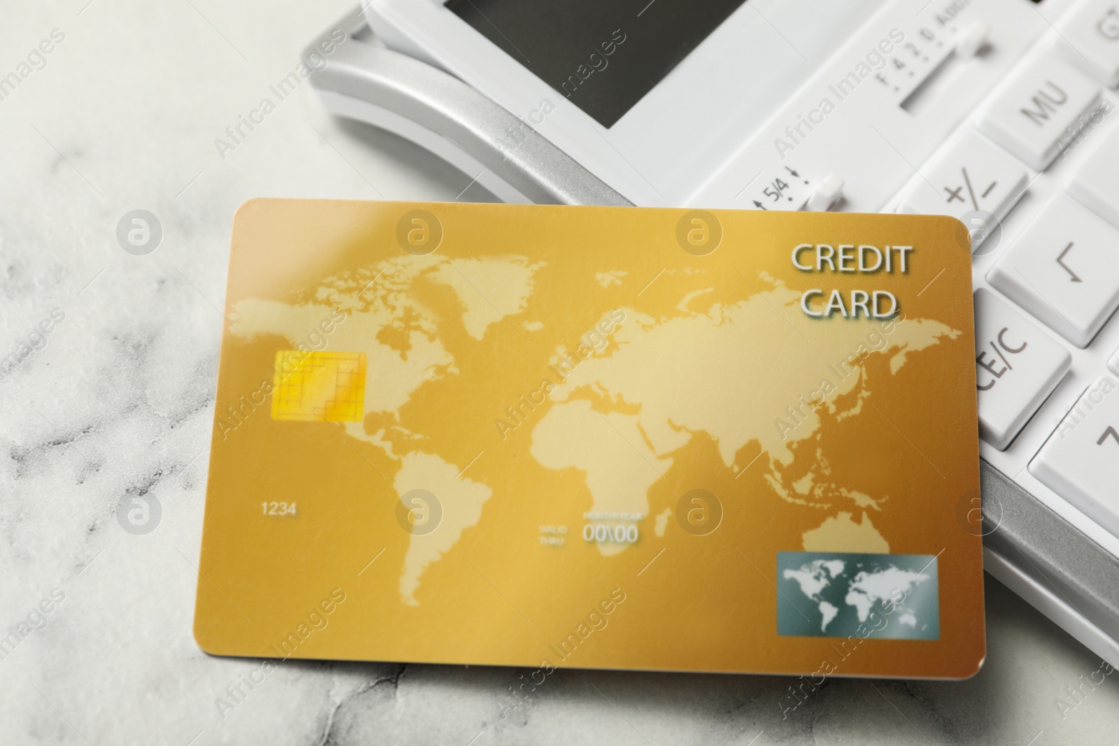 Photo of Credit card and calculator on white marble table, closeup