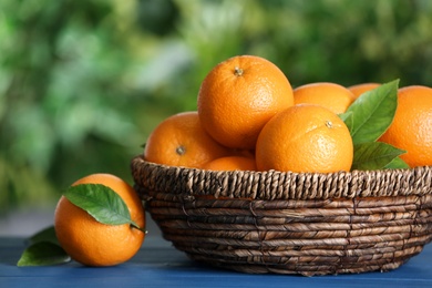 Fresh ripe oranges on blue wooden table against blurred background