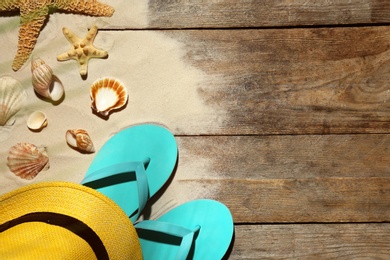 Photo of Flat lay composition with beach objects, sand and space for text on wooden background