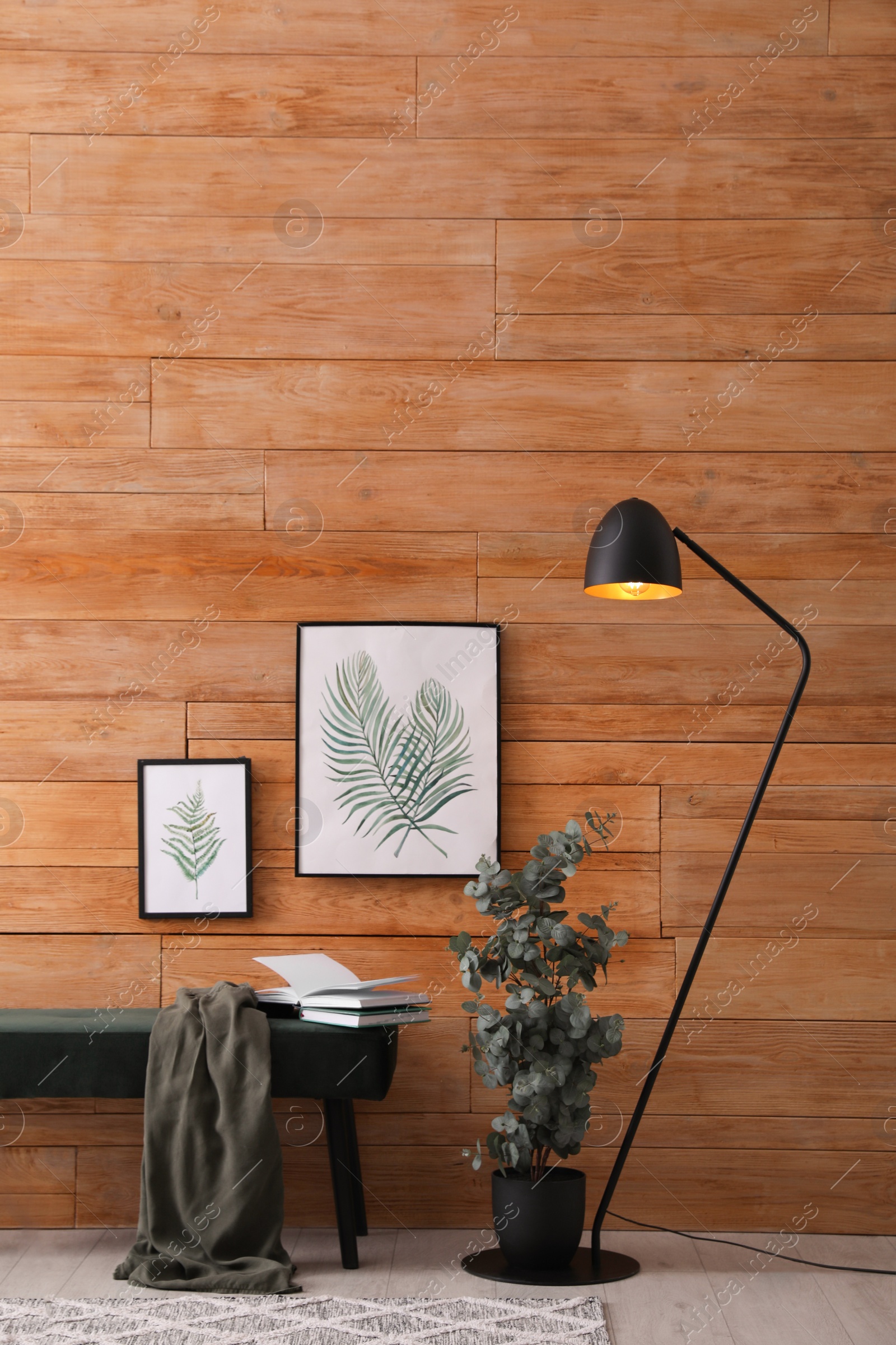 Photo of Stylish room interior with floor lamp, beautiful paintings and potted eucalyptus plant