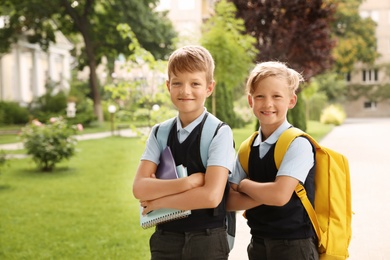 Photo of Little boys in stylish school uniform outdoors