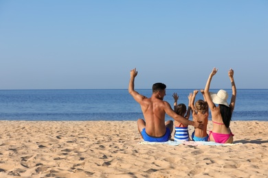 Photo of Family on sandy beach near sea. Summer holidays
