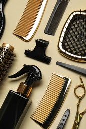 Different hairdresser tools on beige background, flat lay