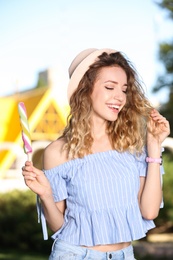 Happy young woman with delicious ice cream outdoors