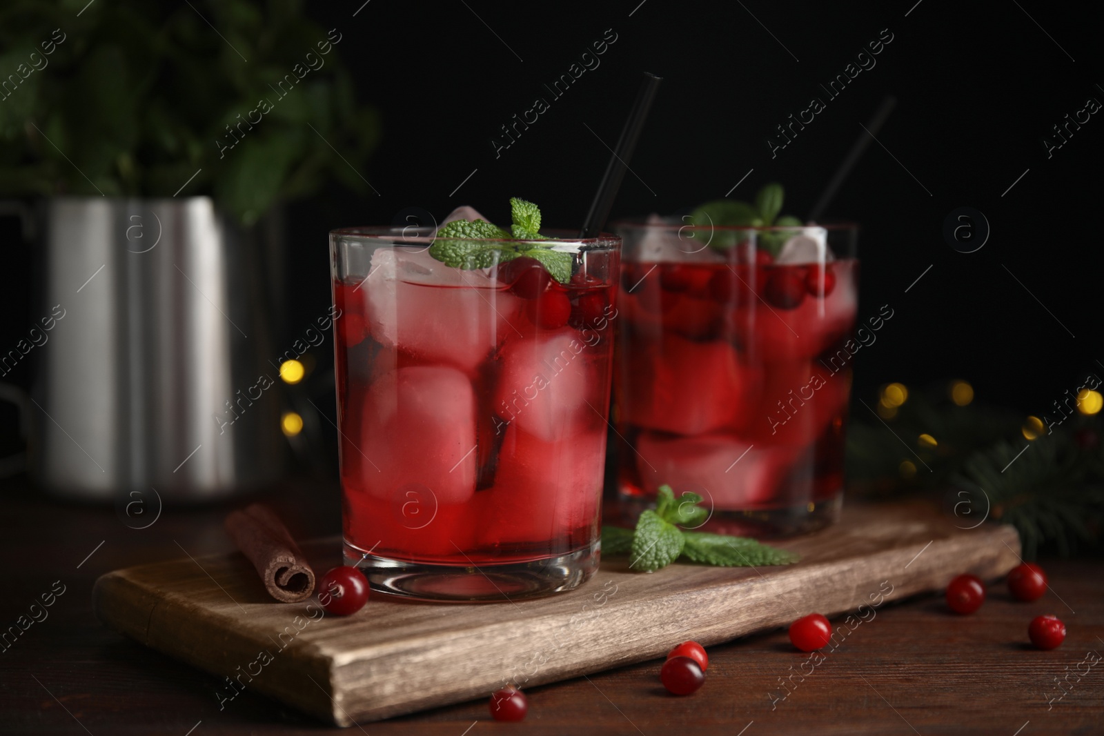 Photo of Tasty refreshing cranberry cocktail with mint on wooden table