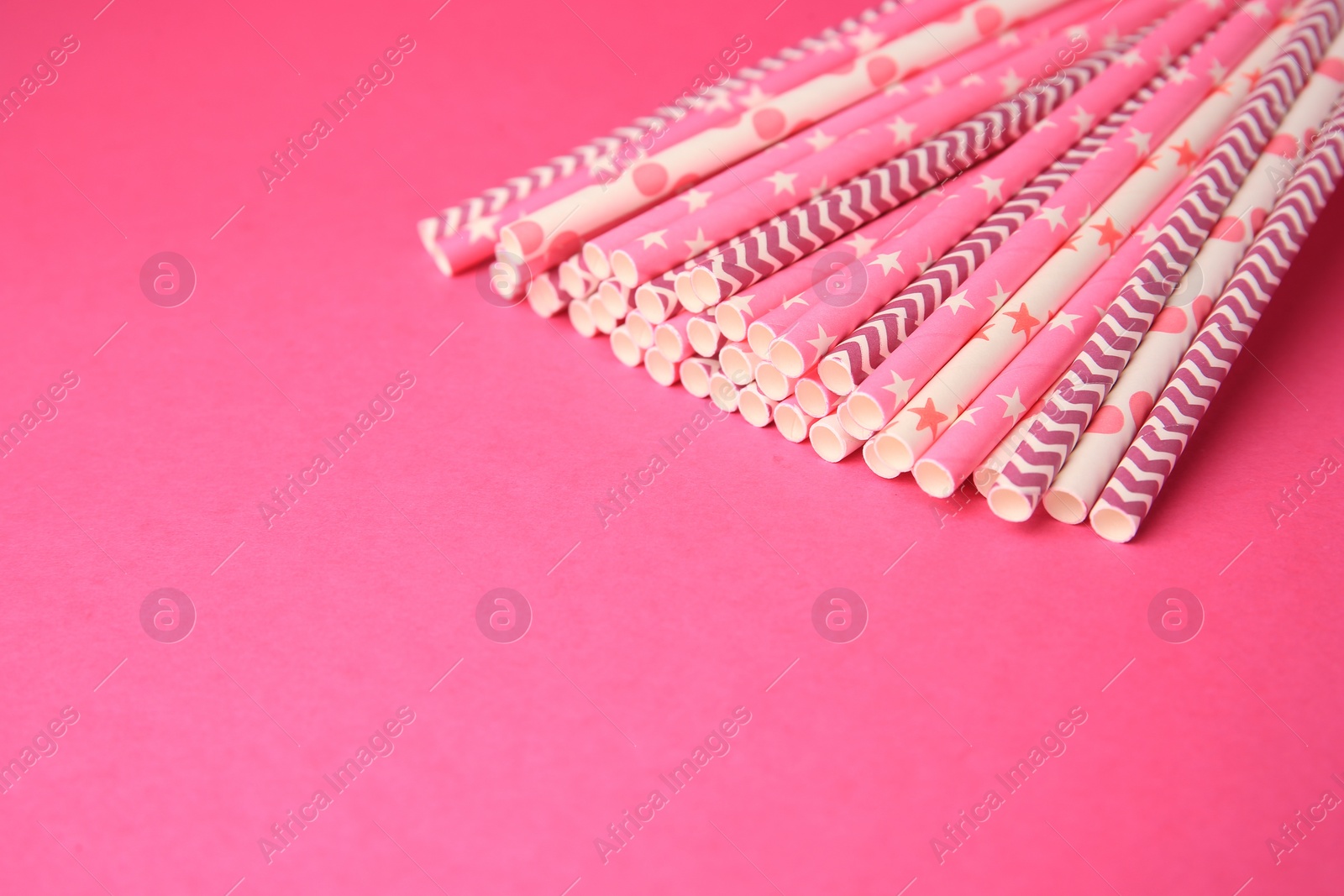 Photo of Many paper drinking straws on pink background. Space for text