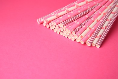 Many paper drinking straws on pink background. Space for text