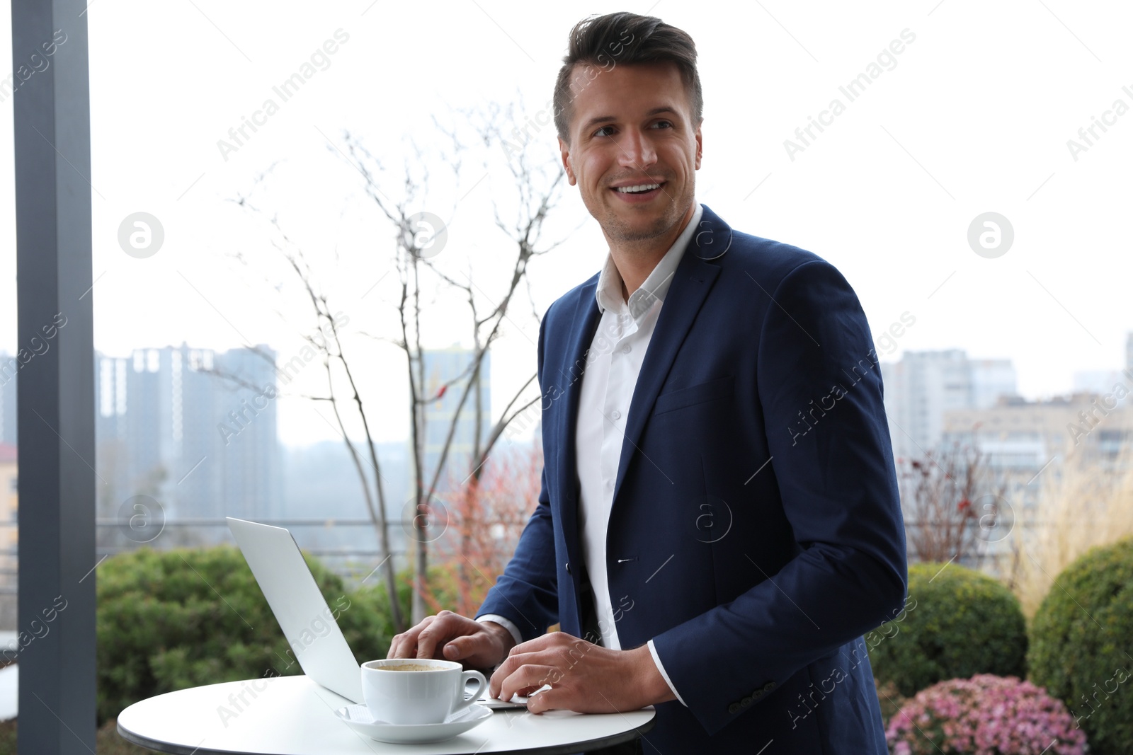 Photo of Businessman working with laptop in outdoor cafe. Corporate blog