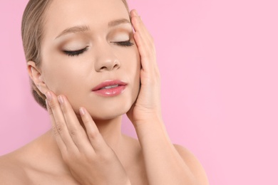 Photo of Portrait of young woman with beautiful face on pink background, closeup. Space for text