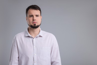 Photo of Portrait of sad man on grey background, space for text