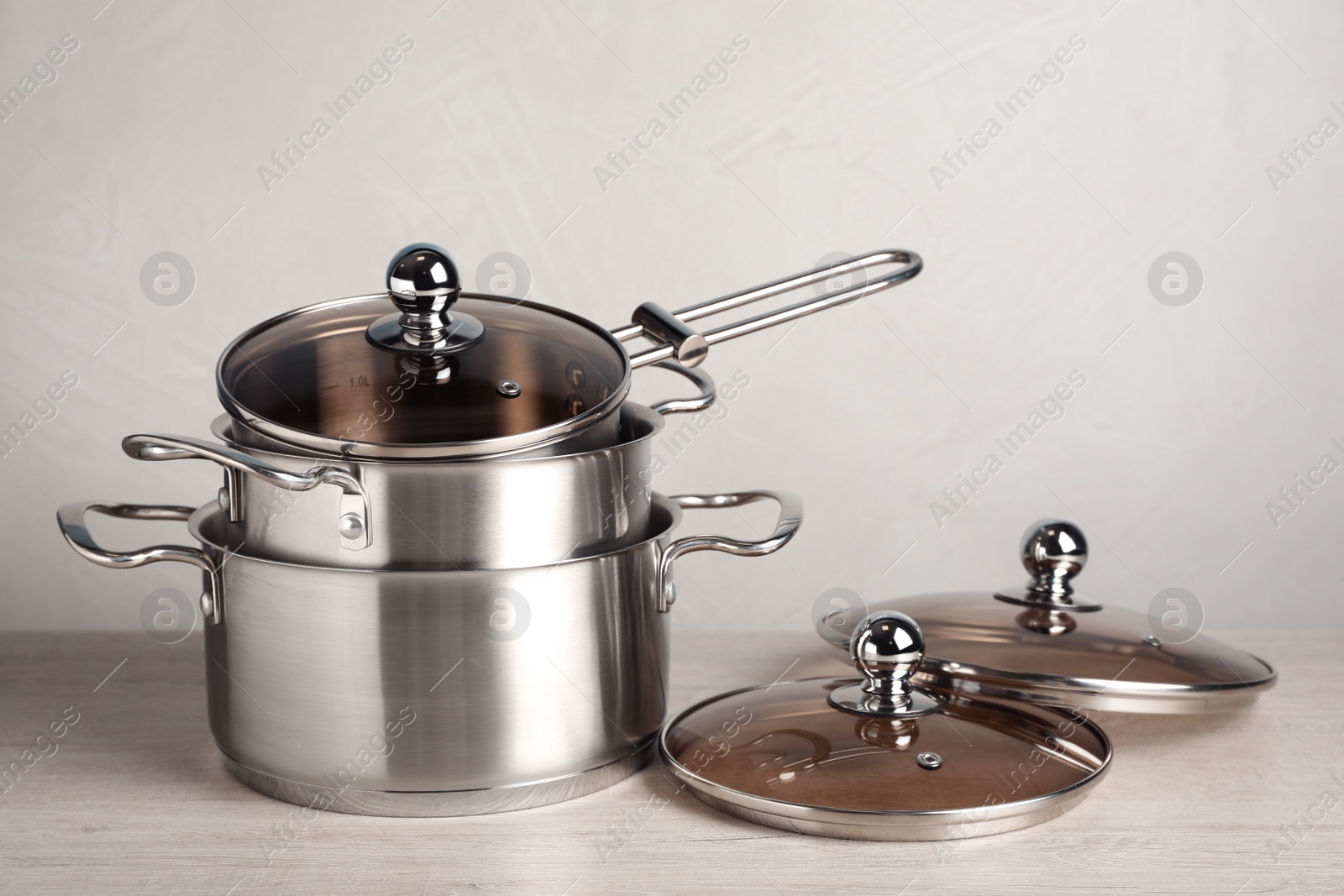 Photo of New cookware set on white wooden table