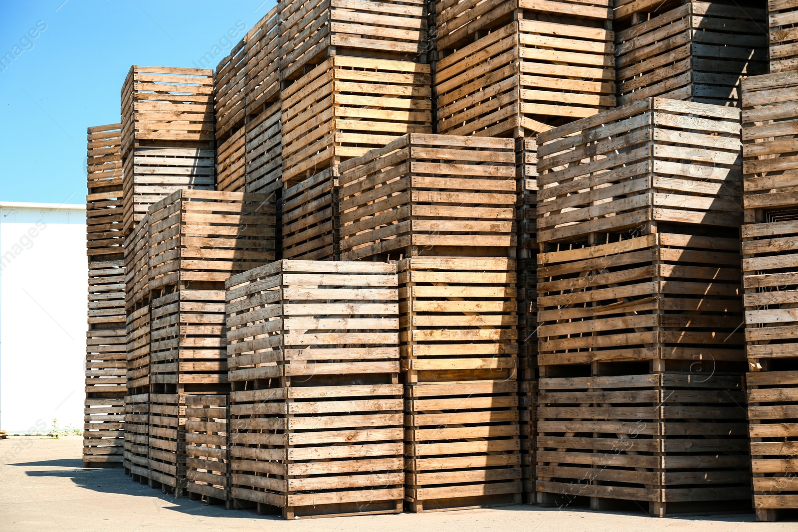 Photo of Pile of empty wooden crates outdoors on sunny day