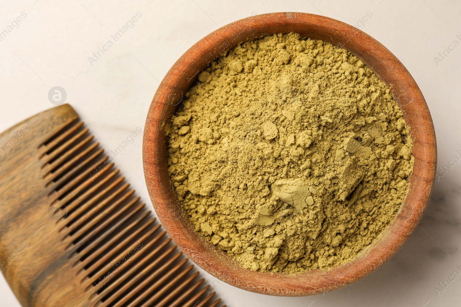 Photo of Comb and henna powder on white marble table, flat lay