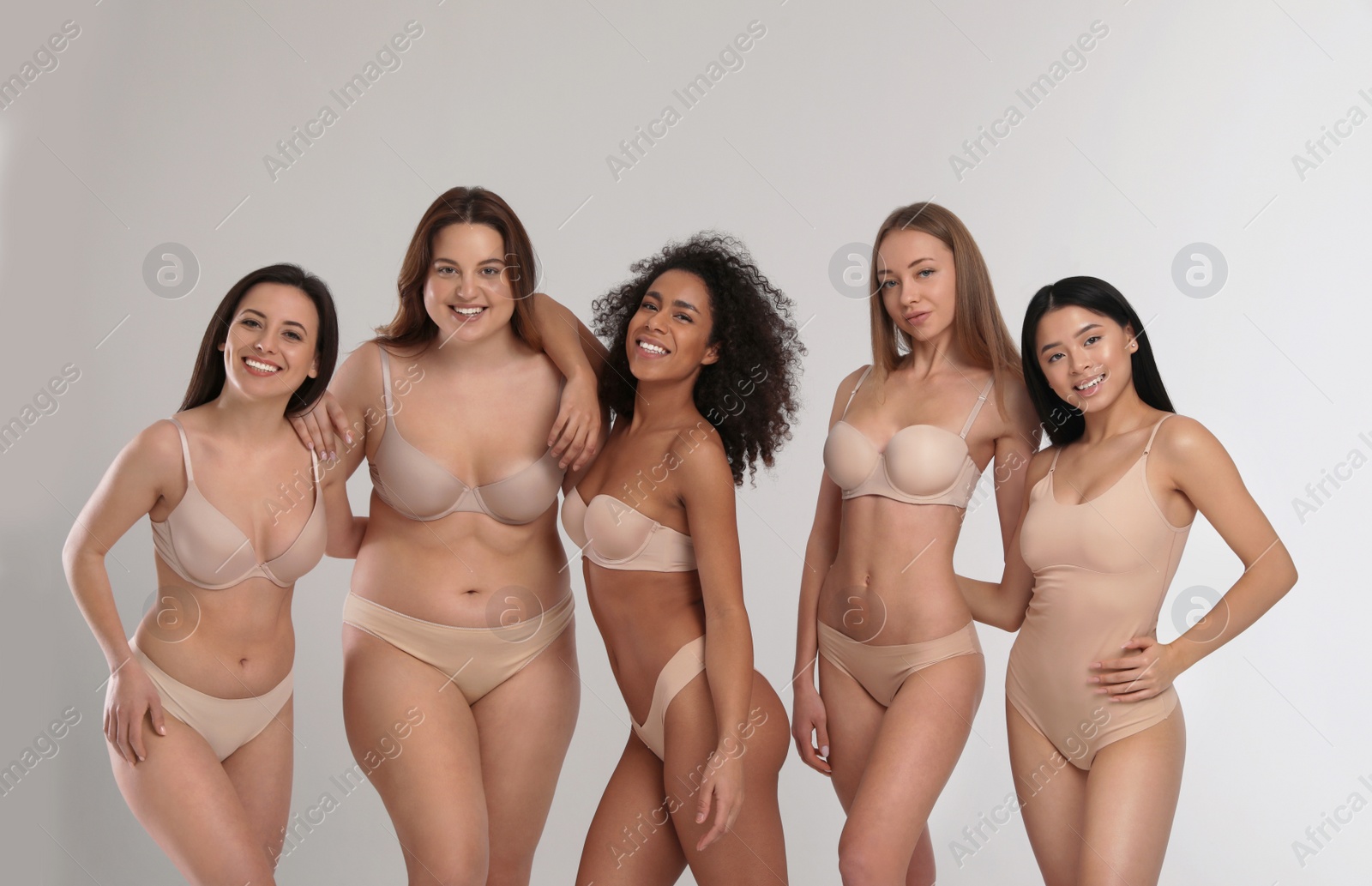 Photo of Group of women with different body types in underwear on light background