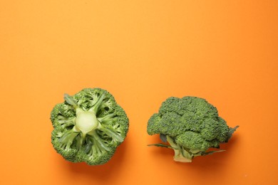 Fresh tasty broccoli on orange background, flat lay. Space for text