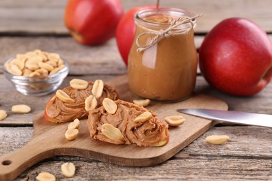 Fresh apples with peanut butter on wooden table