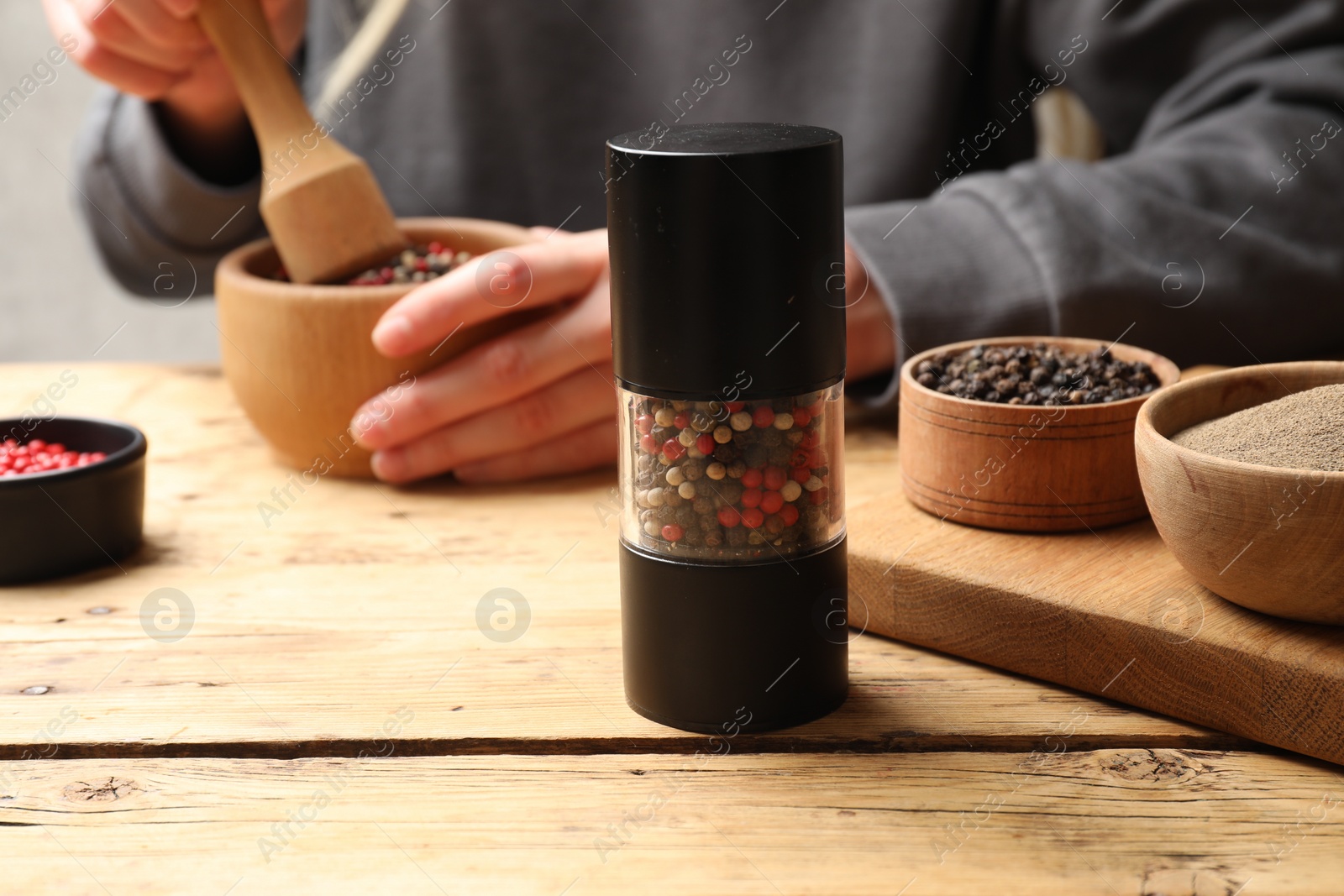 Photo of Ground pepper and grains on wooden table, selective focus. Space for text