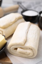 Photo of Raw puff pastry dough on table, closeup