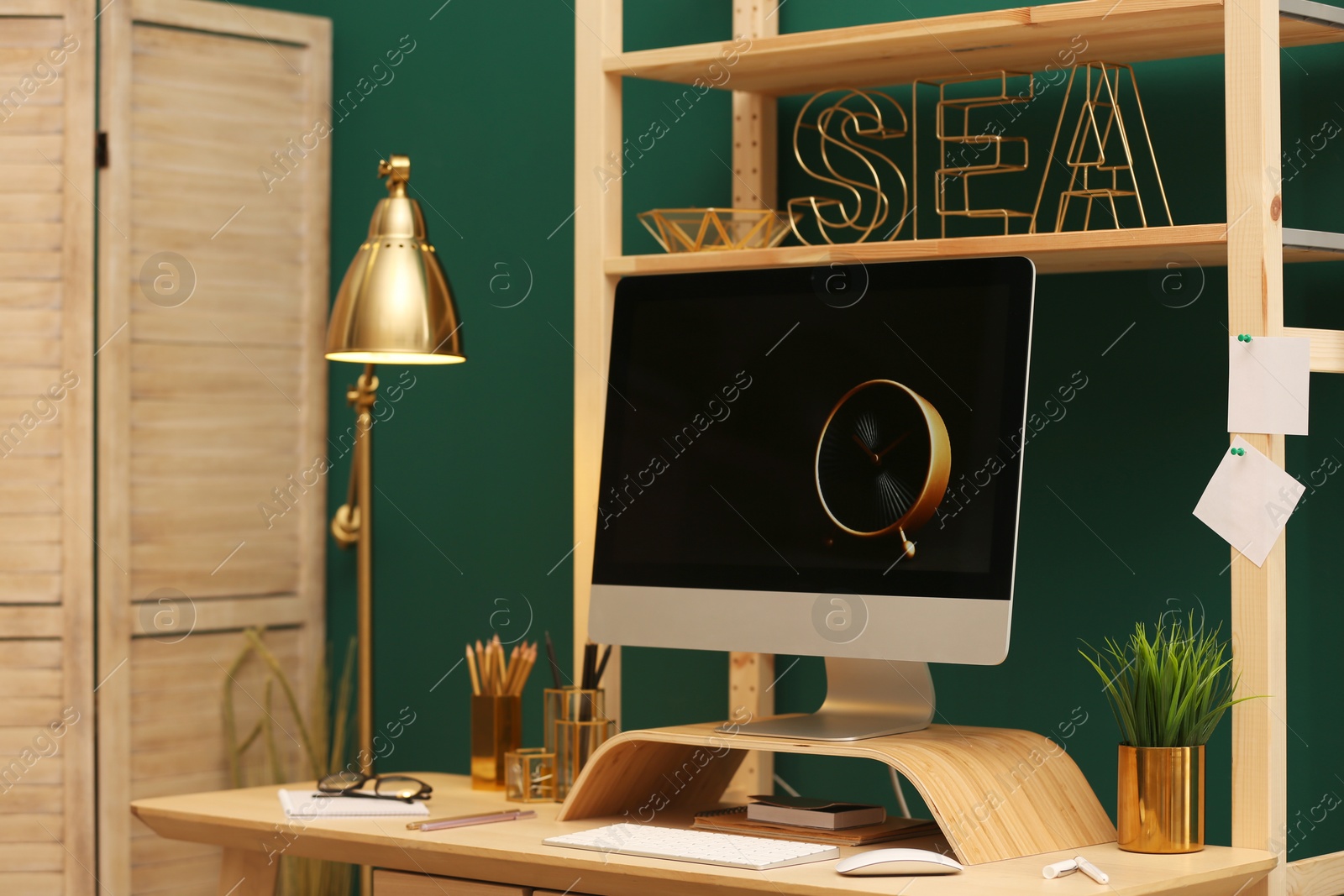 Photo of Stylish room interior with modern workplace at color wall