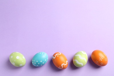 Photo of Beautiful painted Easter eggs on color background, flat lay. Space for text