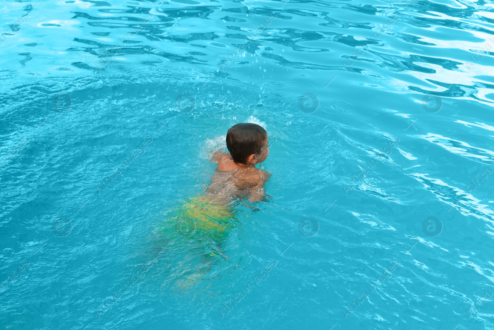 Photo of Little child in outdoor swimming pool. Dangerous situation