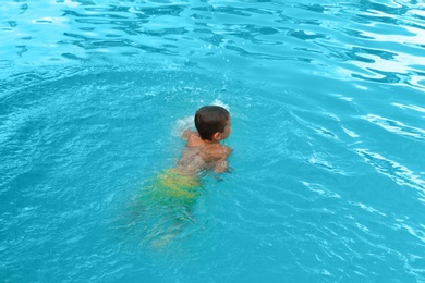 Little child in outdoor swimming pool. Dangerous situation