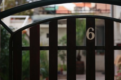 Photo of Plate with house number six on metal fence