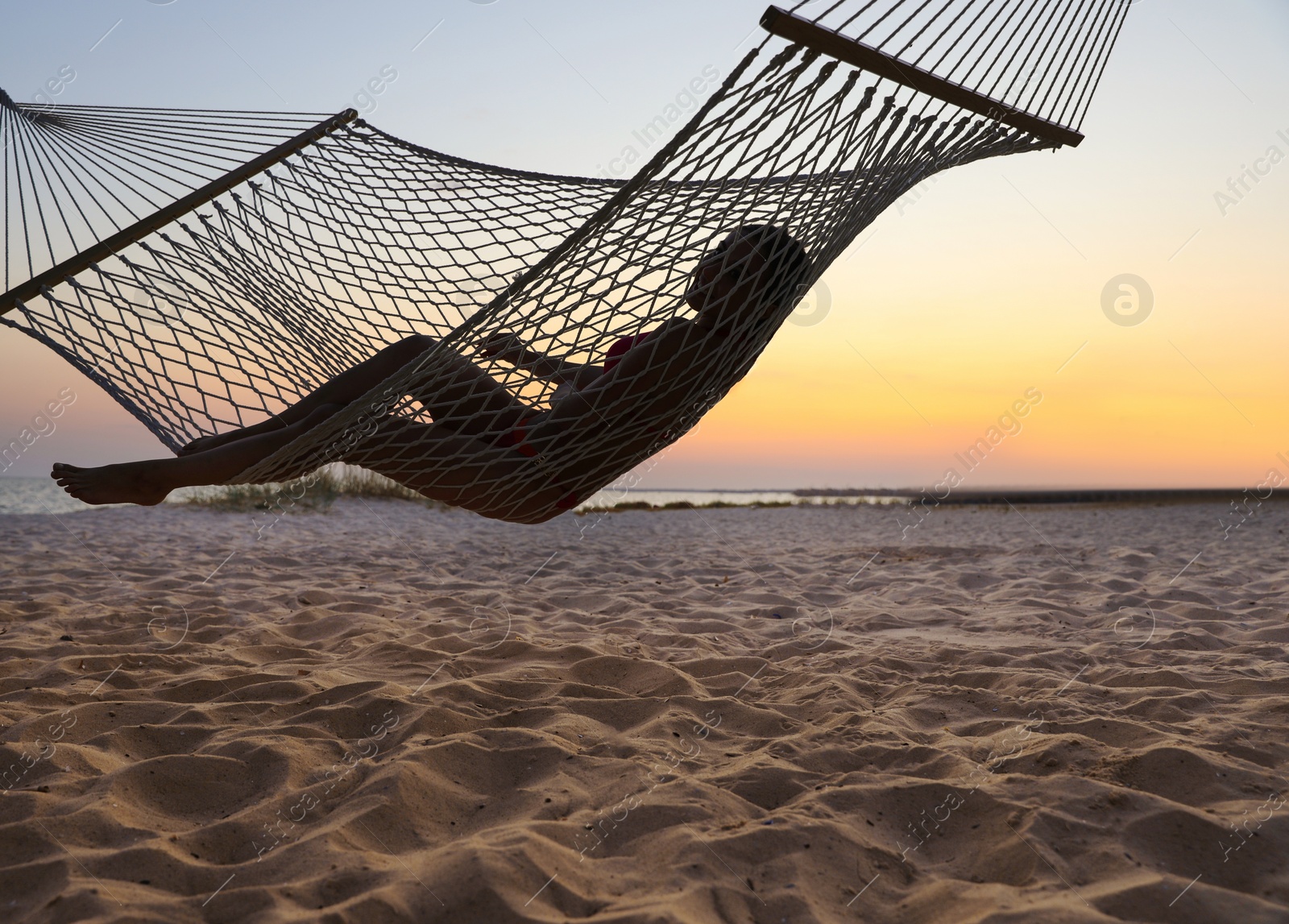 Photo of Young woman relaxing in hammock on beach