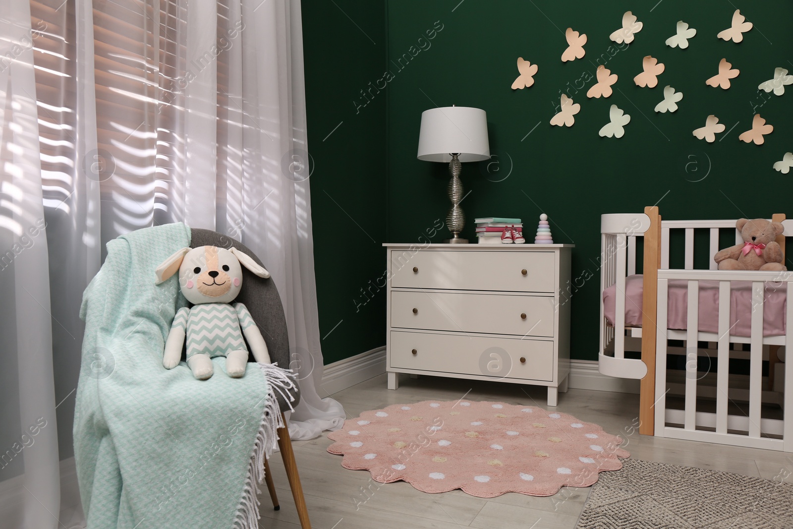 Photo of Beautiful baby room interior with stylish furniture and comfortable crib