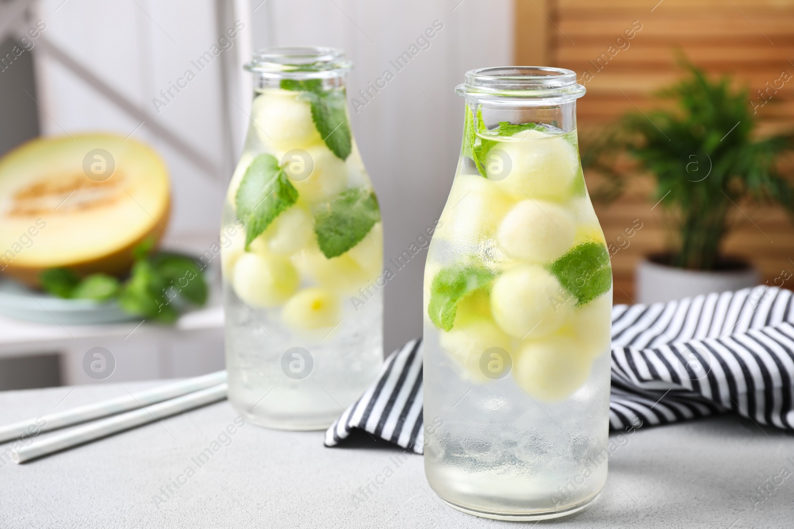 Photo of Tasty melon ball drink on light grey table indoors