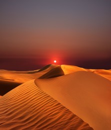 Image of Beautiful view of sandy desert at sunset