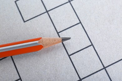 Photo of Pencil on blank crossword, top view. Space for text