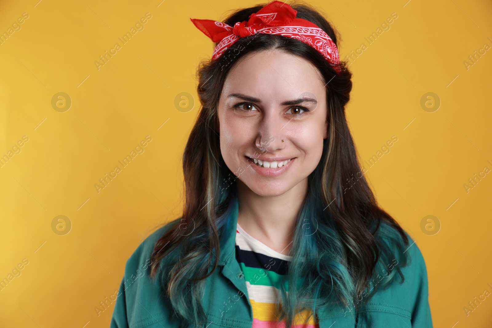 Photo of Beautiful young woman with nose piercing on yellow background