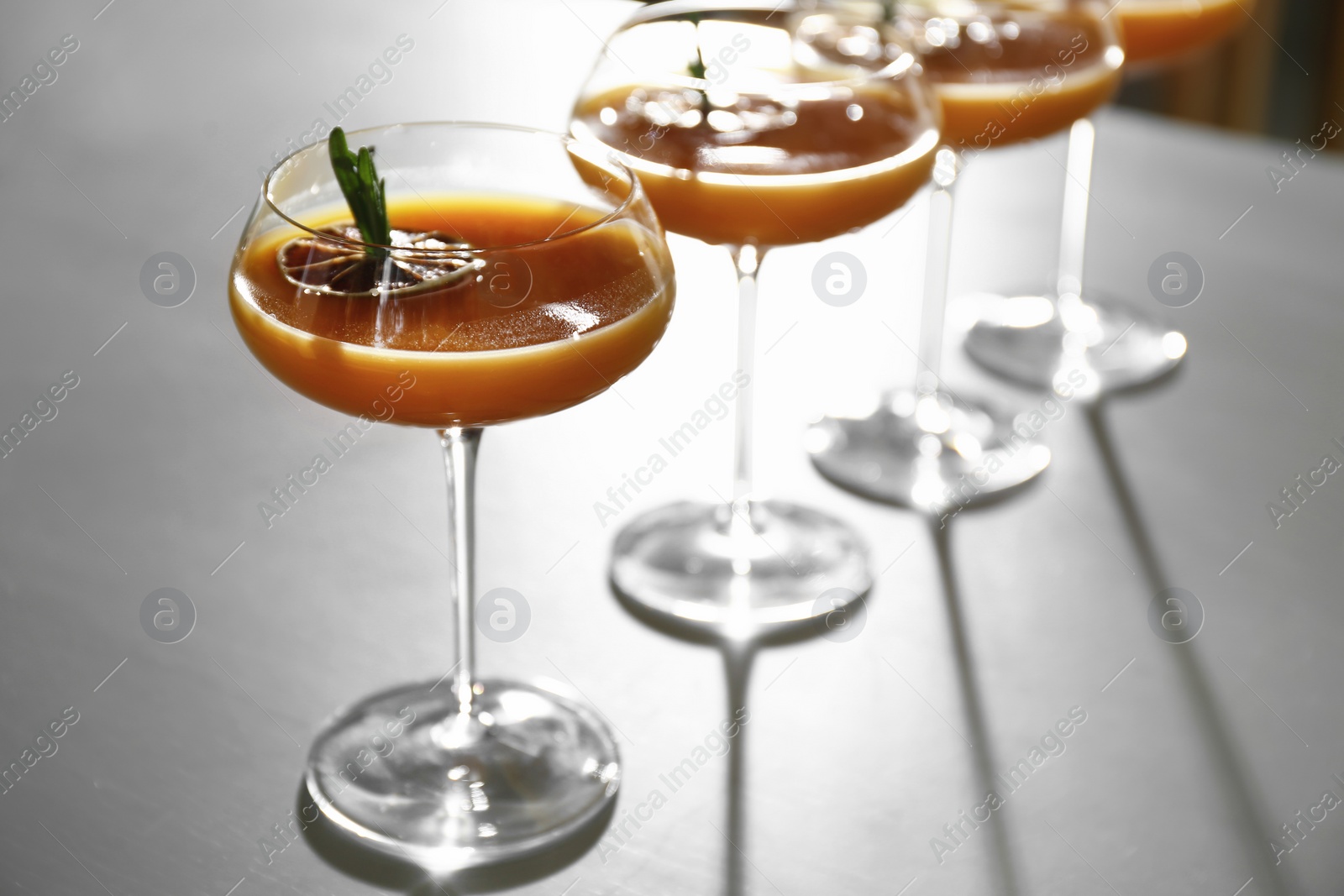 Photo of Glasses of delicious cocktail with vodka on table in bar