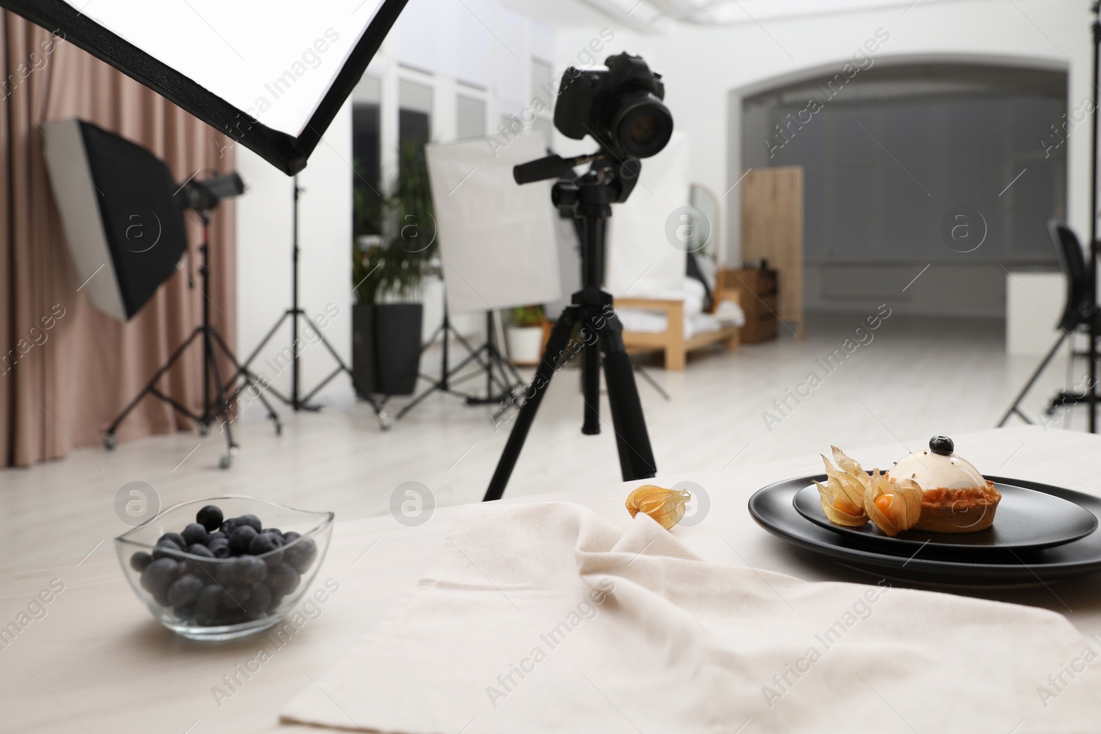 Photo of Professional equipment and composition with delicious dessert on wooden table in studio. Food photography