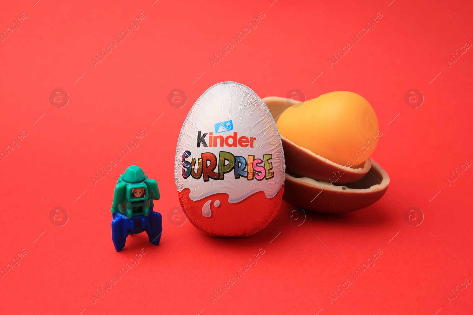 Photo of Sveti Vlas, Bulgaria - June 29, 2023: Kinder Surprise Eggs, plastic capsule and toy space rocket on red background