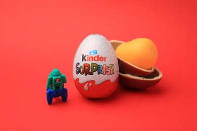 Sveti Vlas, Bulgaria - June 29, 2023: Kinder Surprise Eggs, plastic capsule and toy space rocket on red background