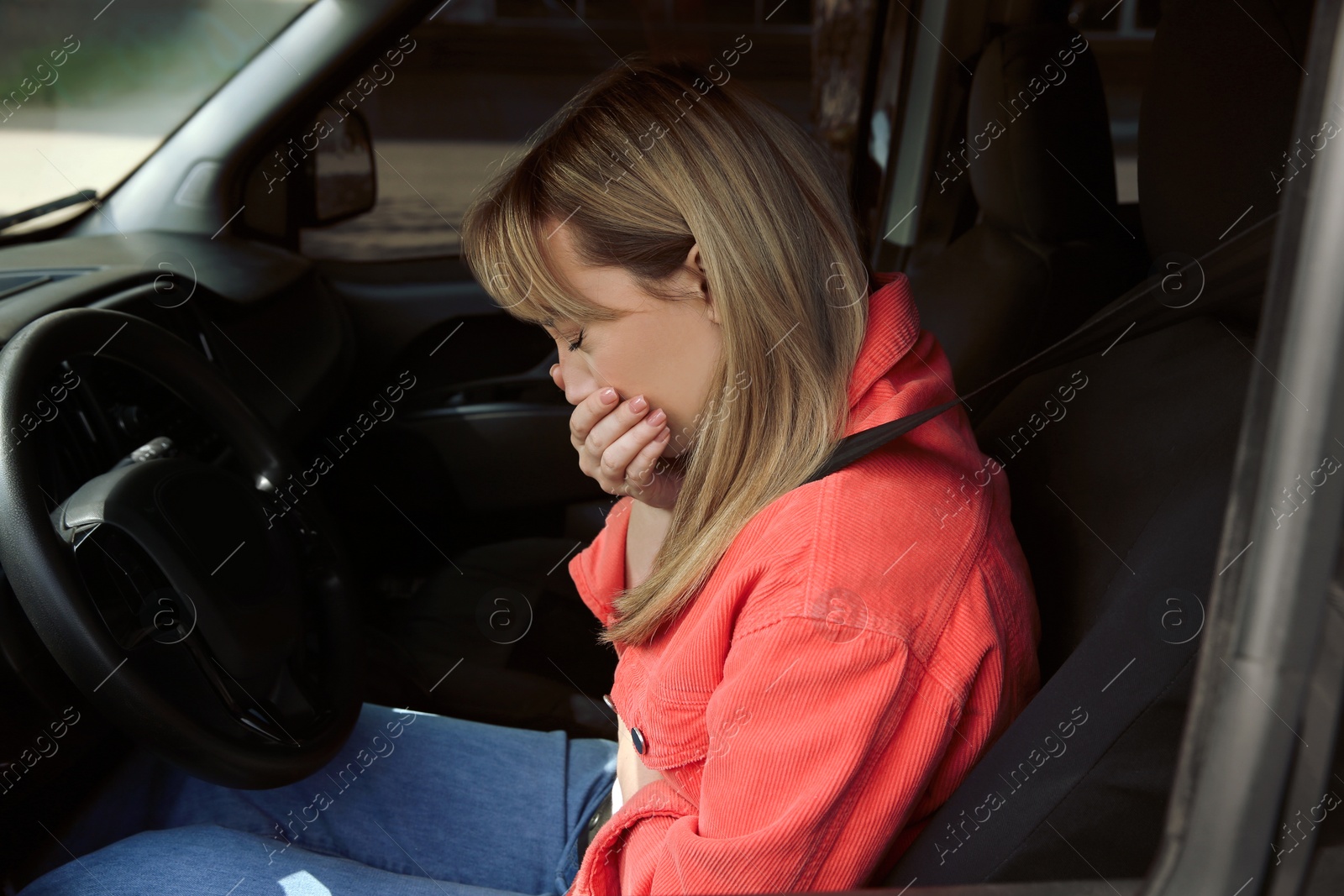 Photo of Young woman suffering from nausea in car