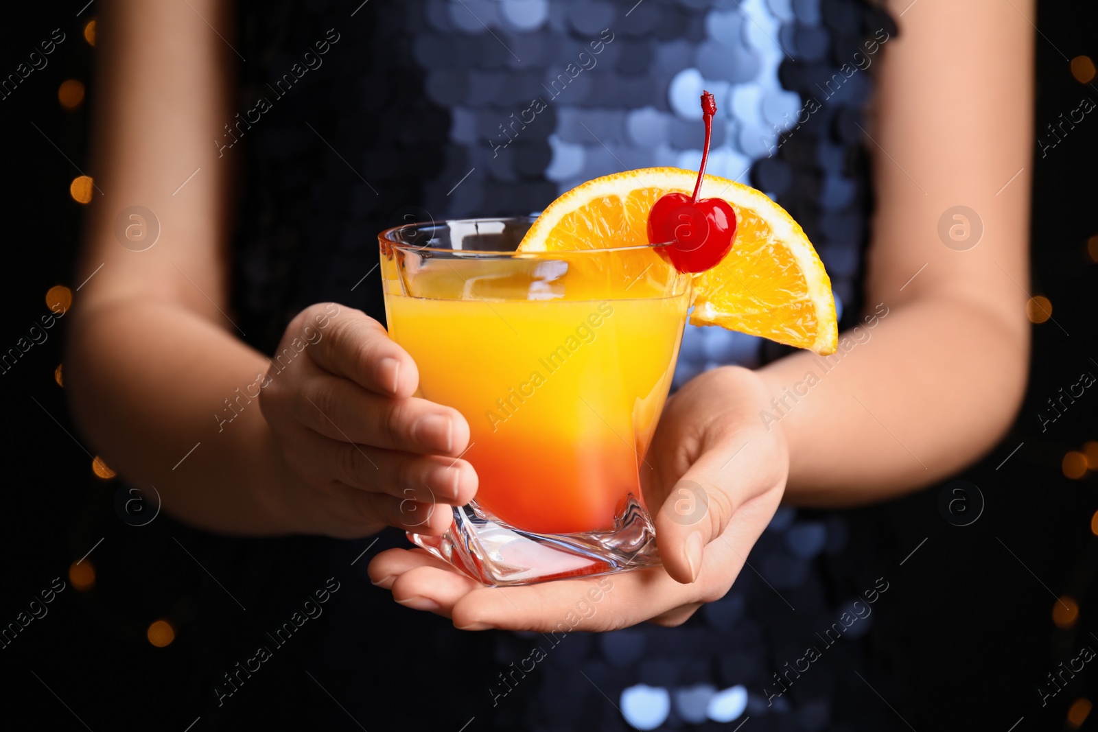 Photo of Woman with glass of Tequila Sunrise, closeup. Delicious alcoholic cocktail