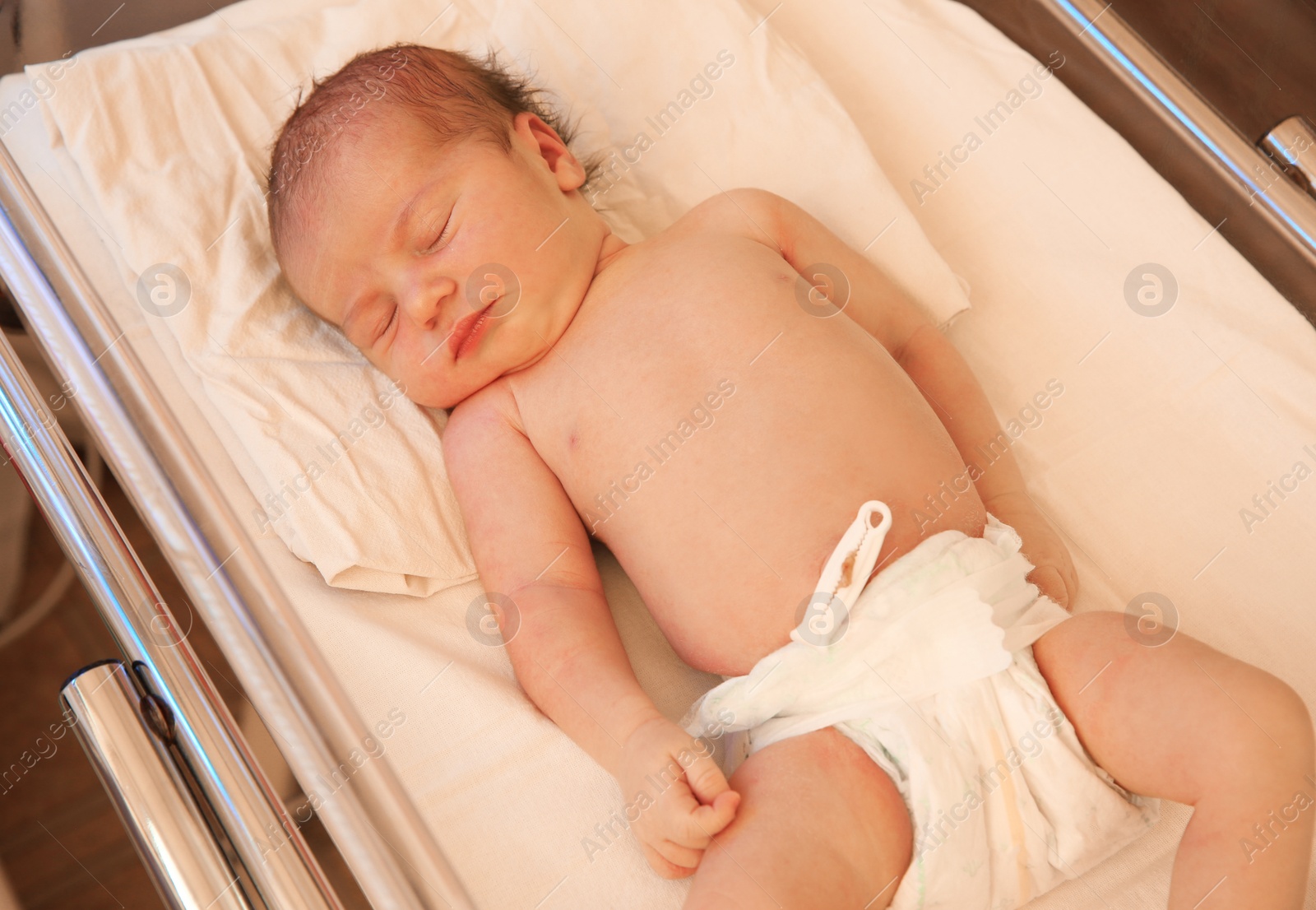 Photo of Newborn child sleeping on bed in hospital