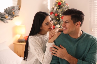 Photo of Happy couple near Christmas tree at home