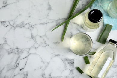 Photo of Fresh aloe drink and leaves on white marble table, flat lay. Space for text