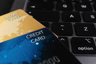 Photo of Two plastic credit cards on laptop, closeup