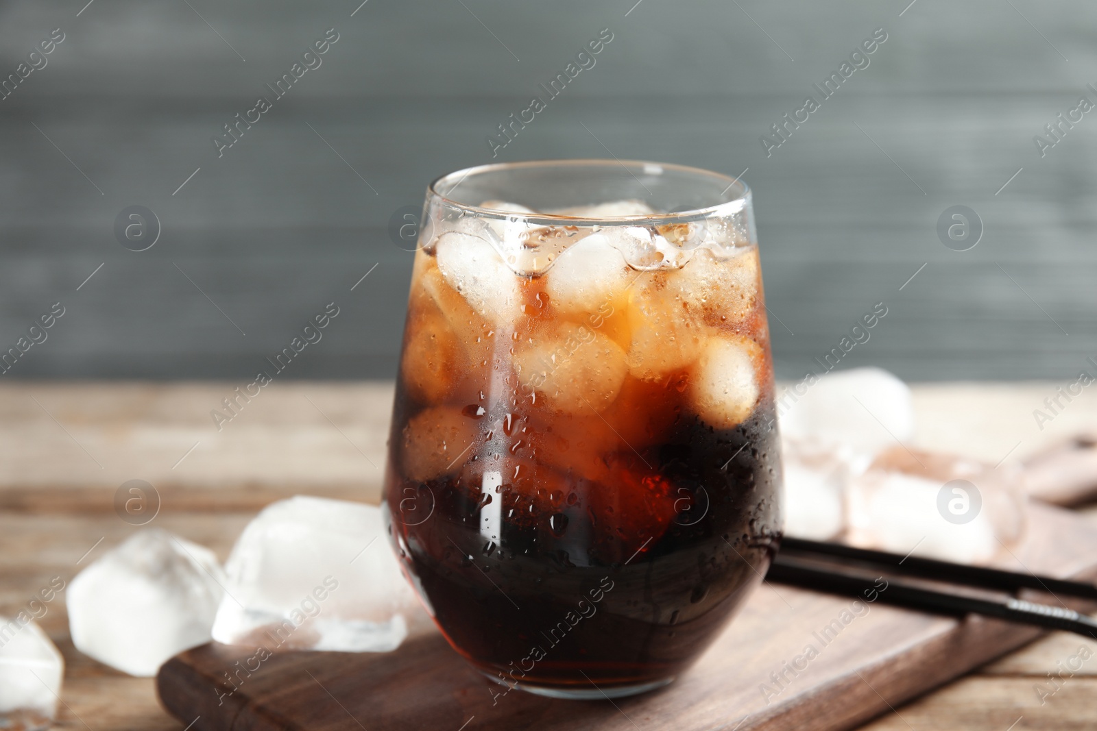 Photo of Composition with glass of refreshing cola on table