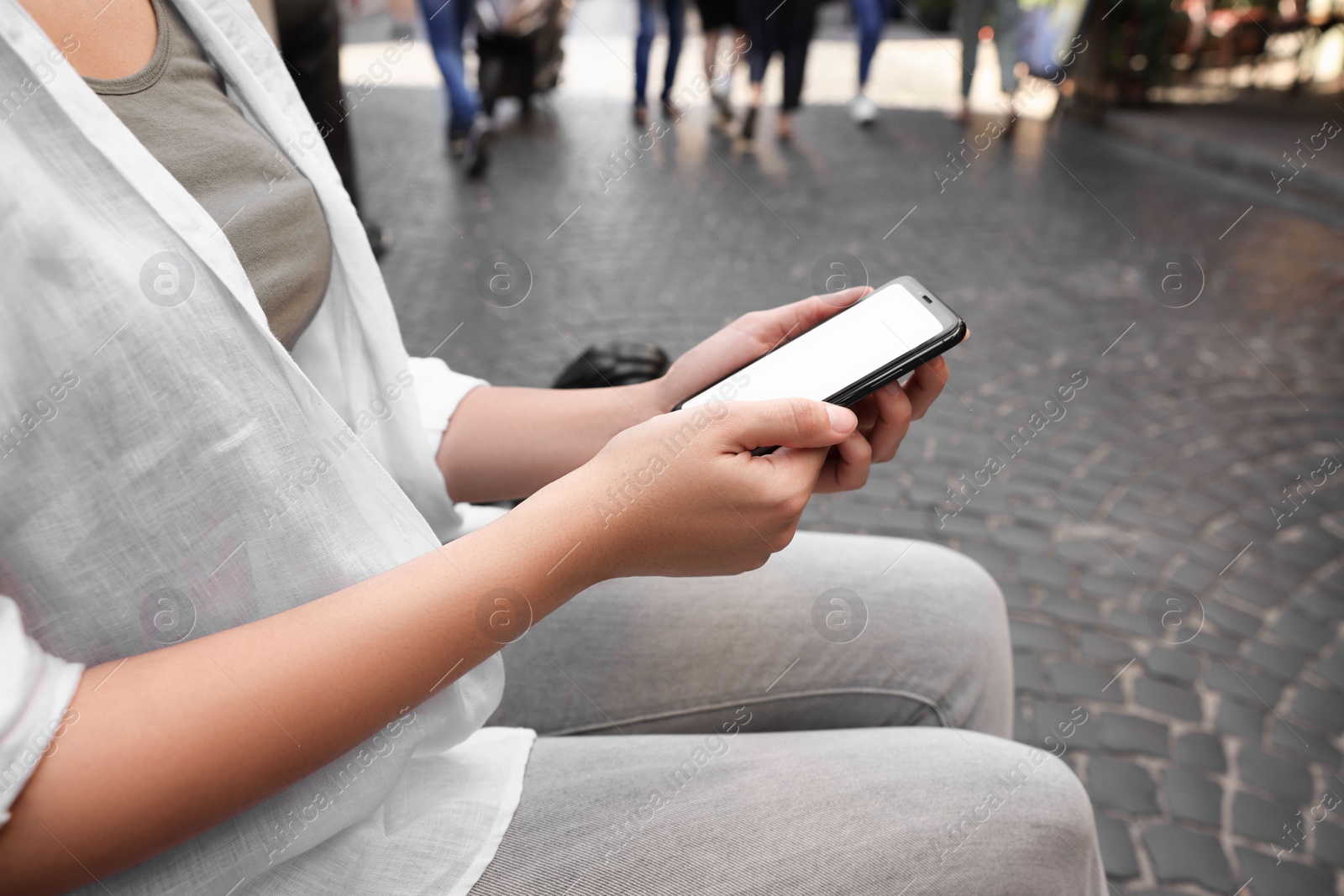 Photo of Young woman with smartphone outdoors, closeup view