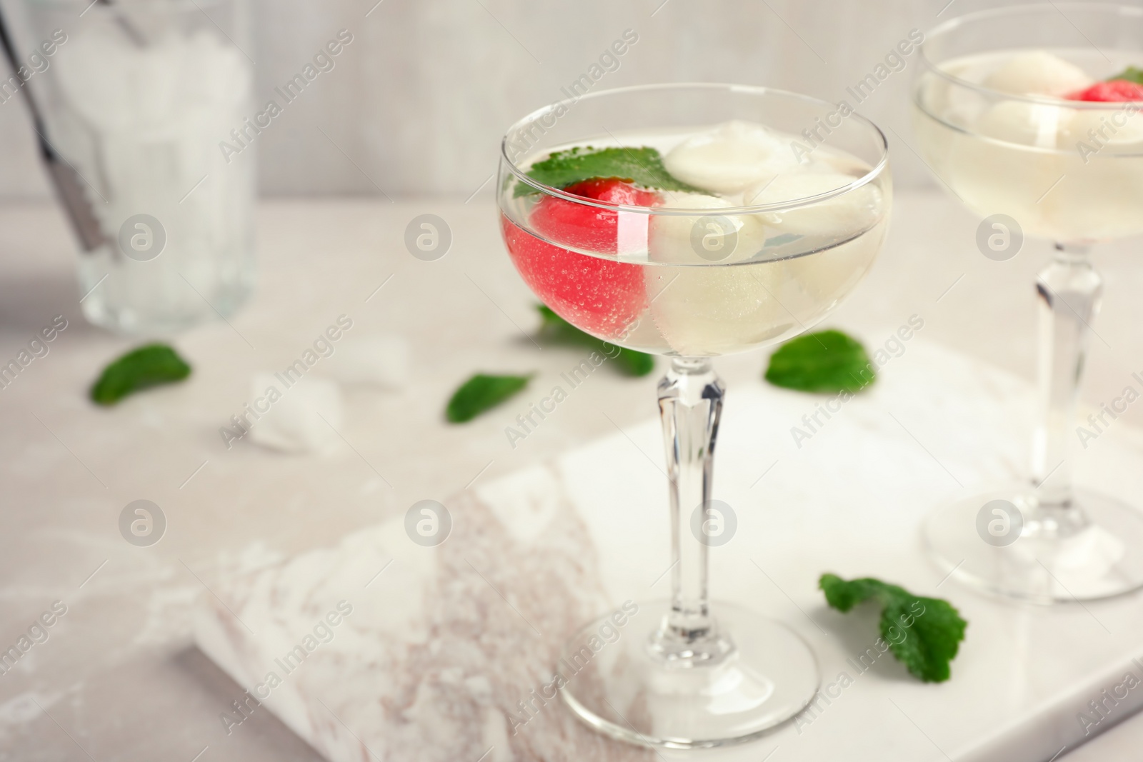 Photo of Glasses with tasty melon and watermelon ball drinks on light table