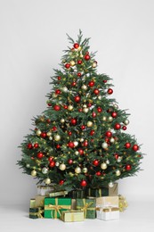 Photo of Beautiful Christmas tree and gift boxes on white background